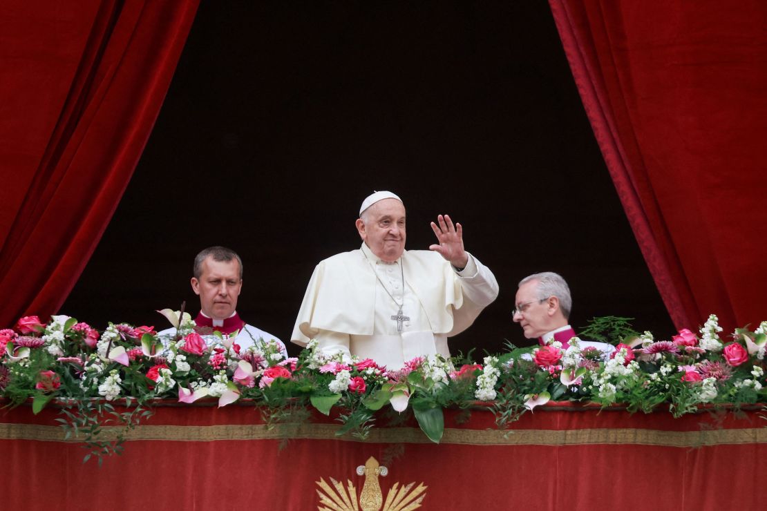 Pope Francis waves from a balcony on Easter Sunday. Francis called for an "immediate ceasefire" during his address.