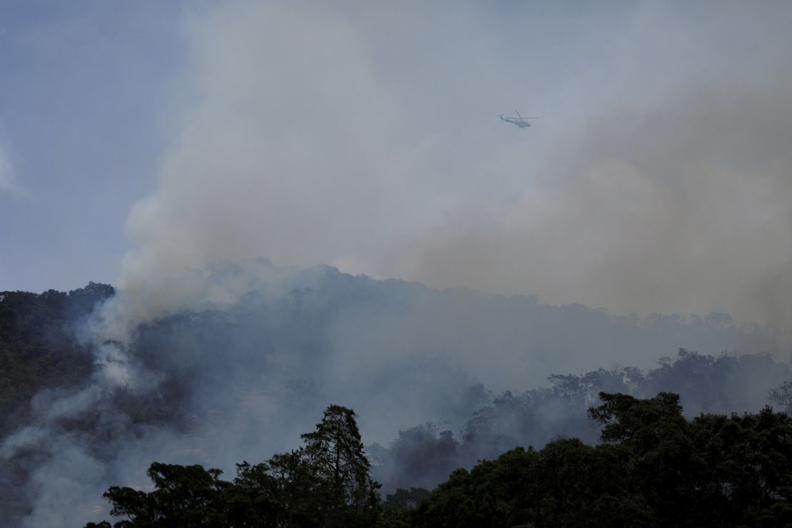 A Bolivarian National Police helicopter flies over during a wildfire in the Henri Pittier National Park on March 29.