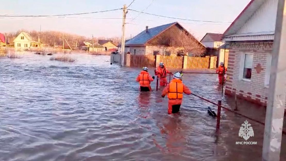 Спасители си проправят път през наводнен жилищен район в град Орск.