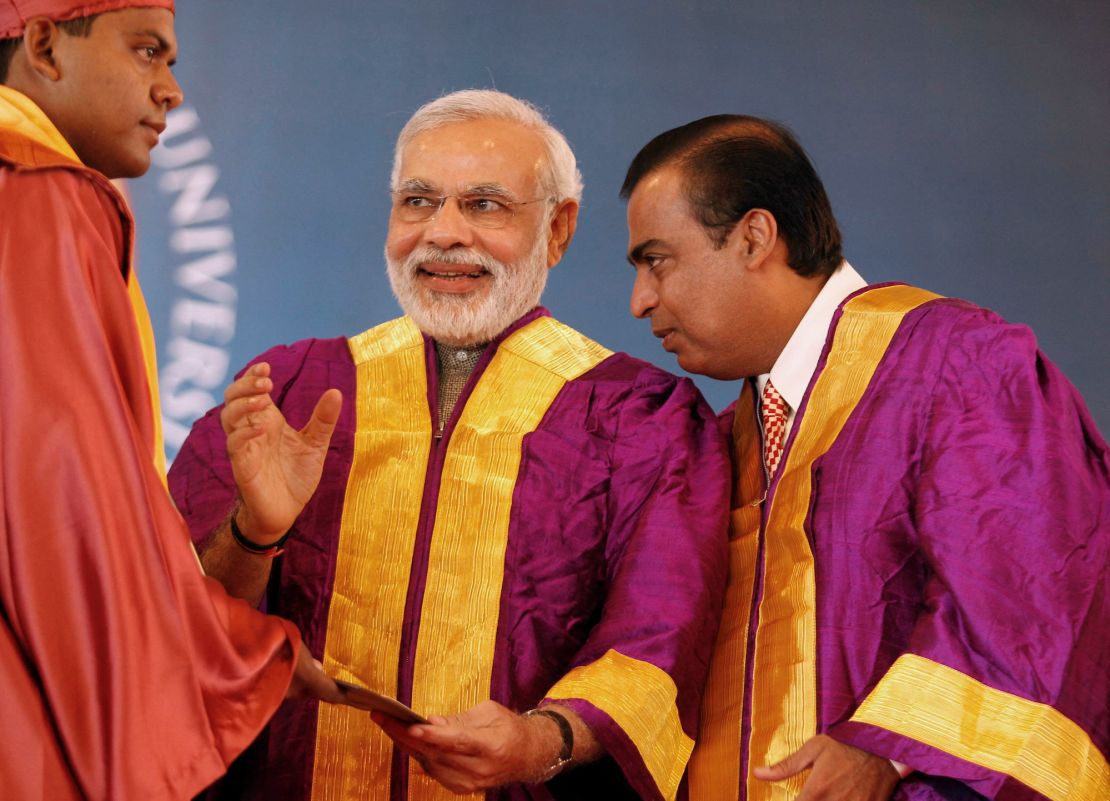 Mukesh Ambani (right) is pictured with Narendra Modi (center) at a university graduation ceremony in the western Indian state of Gujarat on October 19, 2013.