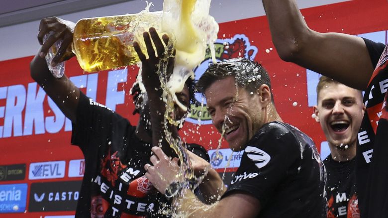 Bayer Leverkusen players pour beer on coach Xabi Alonso during a press conference after winning the team won the Bundesliga title.