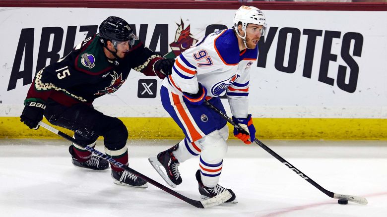 Apr 17, 2024; Tempe, Arizona, USA;  Edmonton Oilers center Connor McDavid (97) moves the puck against Arizona Coyotes center Alex Kerfoot (15) during the second period at Mullett Arena. Mandatory Credit: Mark J. Rebilas-USA TODAY Sports