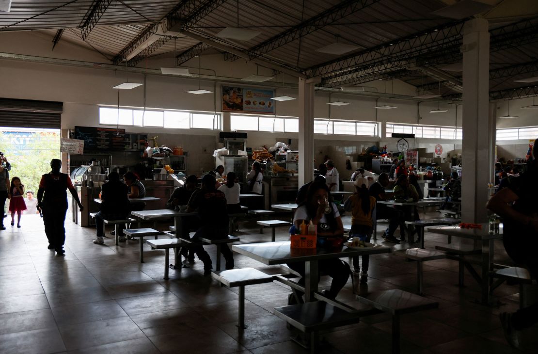 Customers eat in a darkened market square during a power cut in Quito, Ecuador, on April 18.