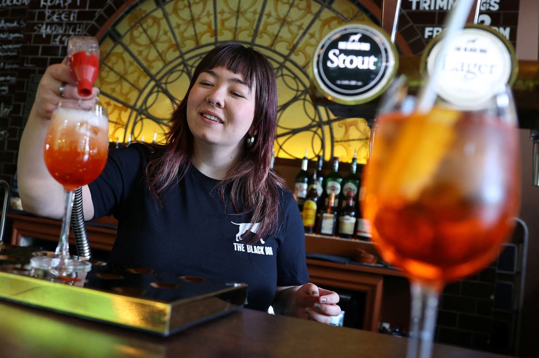 Un employé du pub The Black Dog est photographié en train de préparer un cocktail « Aperol Spritz (Taylor's Version) ».