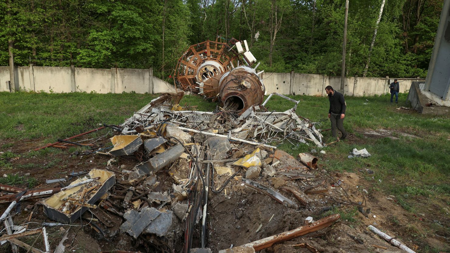 People walk next to a part of a television tower partially destroyed by a Russian missile strike in Kharkiv, Ukraine, April 22, 2024.