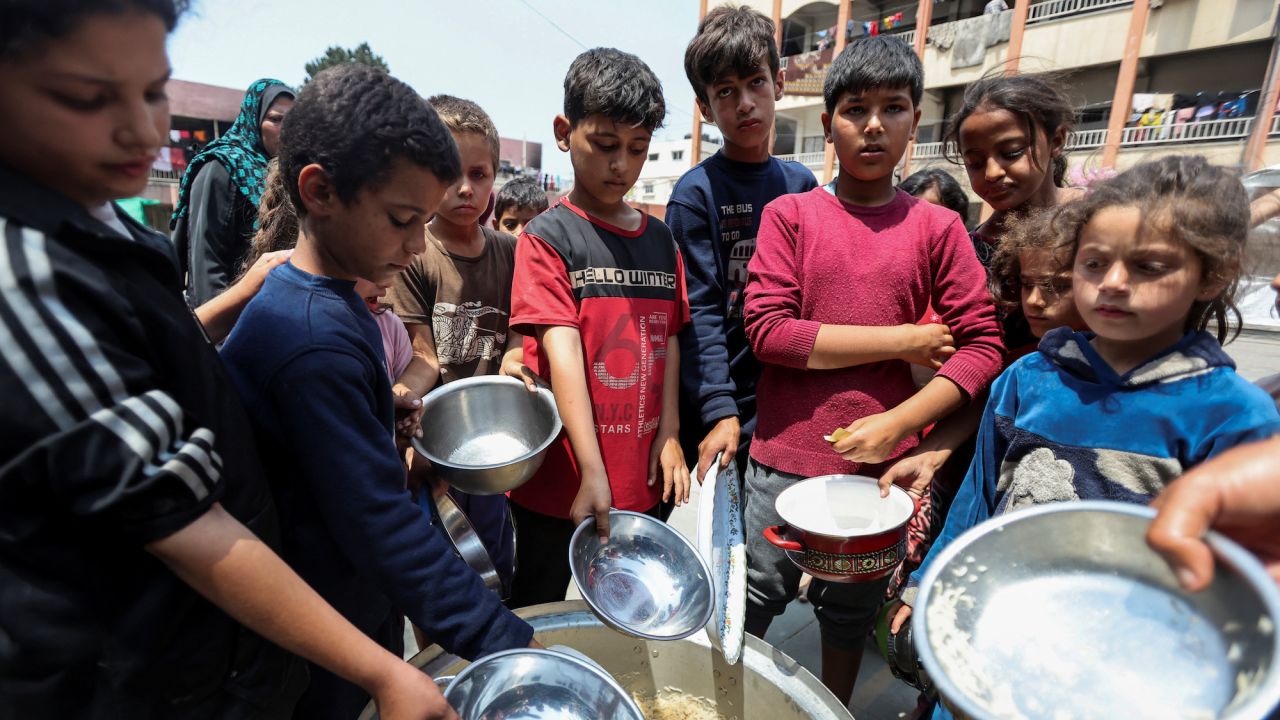 Palestinian children gather to receive food meals cooked by World Central Kitchen (WCK) after the charity resumed operations in central Gaza's Deir Al-Balah on May 1, 2024.