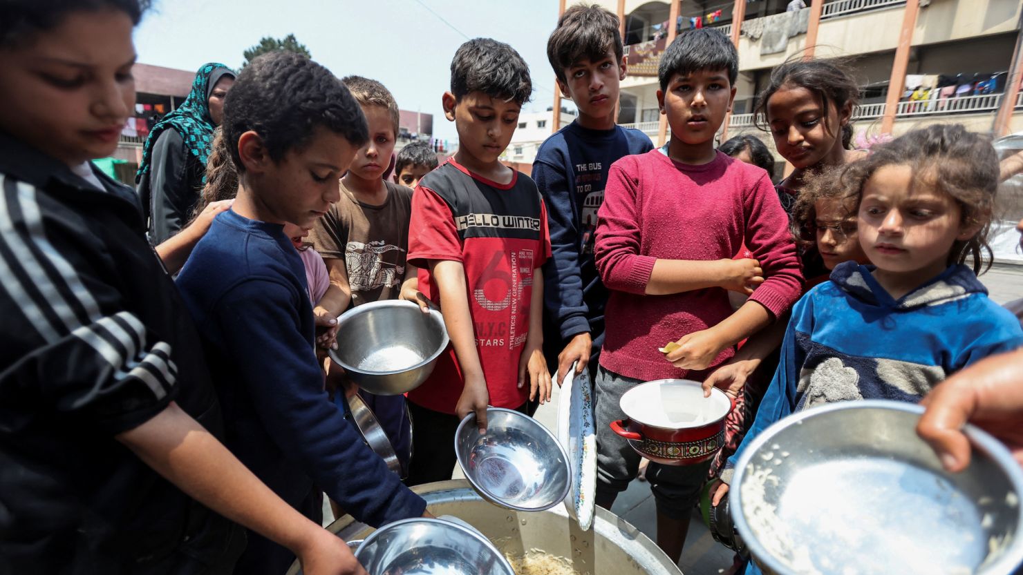 Palestinian children gather to receive meals cooked by World Central Kitchen after the charity resumed operations in central Gaza's Deir Al-Balah on May 1, 2024.