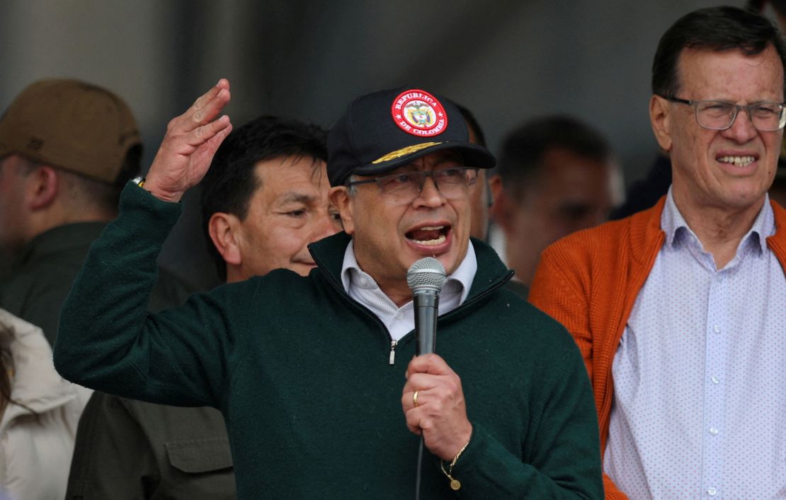 Colombian politician Gustavo Petro speaks into a microphone, one arm excitedly gesturing upward.