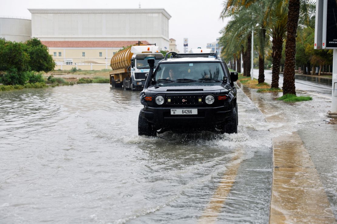 A car drives through a flooded road following a rainstorm in Dubai on May 2, 2024.