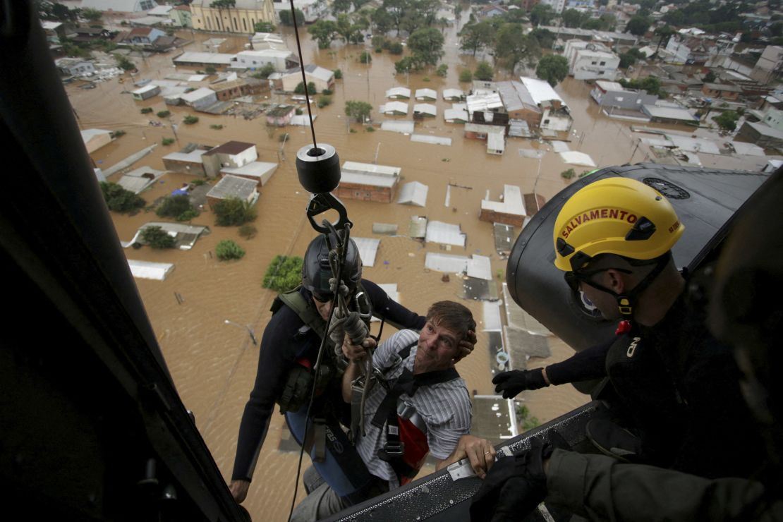 Military firefighters rescue a man using a helicopter.