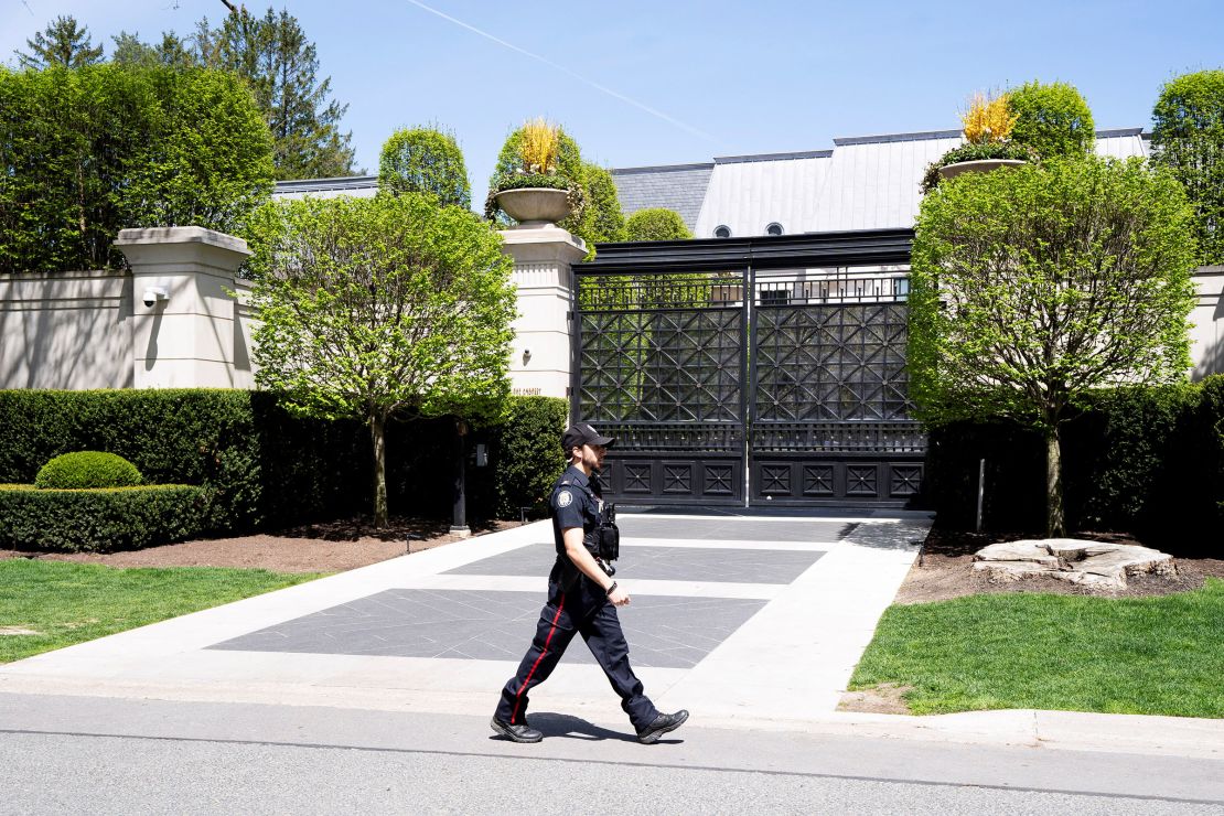 A Toronto police officer walking outside of Drake's mansion in Toronto after a security guard was shot outside the home on Tuesday.