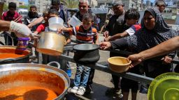 Palestinians gather to receive food cooked from a charity kitchen in Rafah, southern Gaza Strip on May 8, 2024.