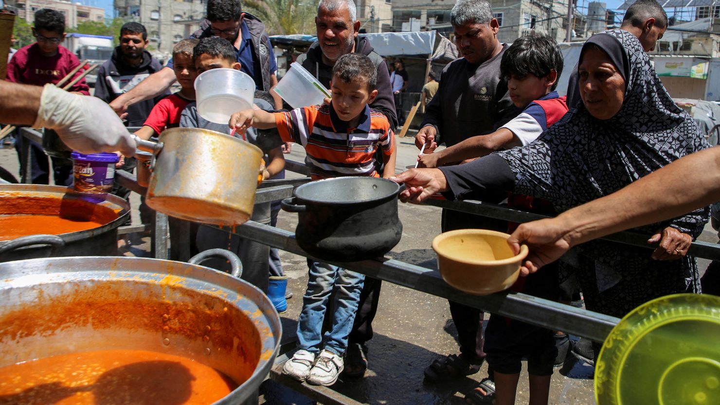 Palestinians gather to receive food cooked from a charity kitchen in Rafah, southern Gaza, on May 8, 2024.