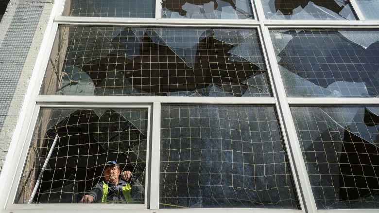 A worker removes shards of glass from a broken window, at a school damaged by a Russian missile strike in Kharkiv, Ukraine on May 8, 2024.