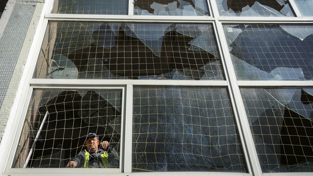 A worker removes shards of glass from a broken window, at a school damaged by a Russian missile strike in Kharkiv, Ukraine on May 8, 2024.