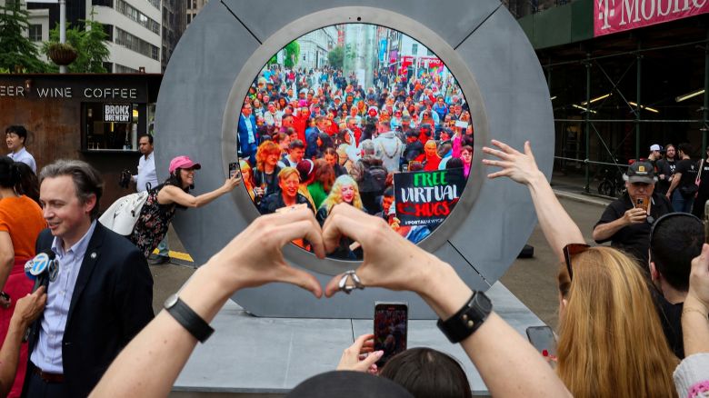 New Yorkers greet people in Dublin during the reveal of The Portal, a public technology sculpture that links with direct connection between Dublin, Ireland and the Flatiron district in Manhattan, in New York City, U.S., May 8, 2024.  REUTERS/Brendan McDermid     