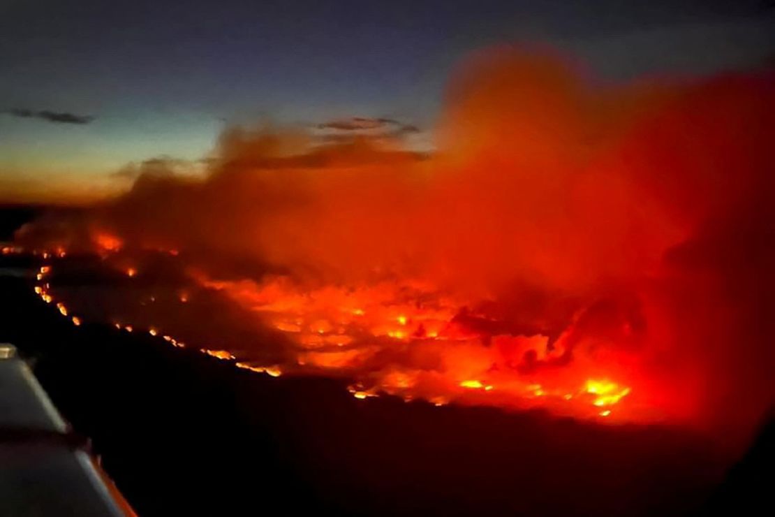 The Parker Lake Fire glows in an aerial photograph taken by a British Columbia Emergency Health Services crew member through the window of an airplane evacuating patients from nearby Fort Nelson, Canada, on Friday.