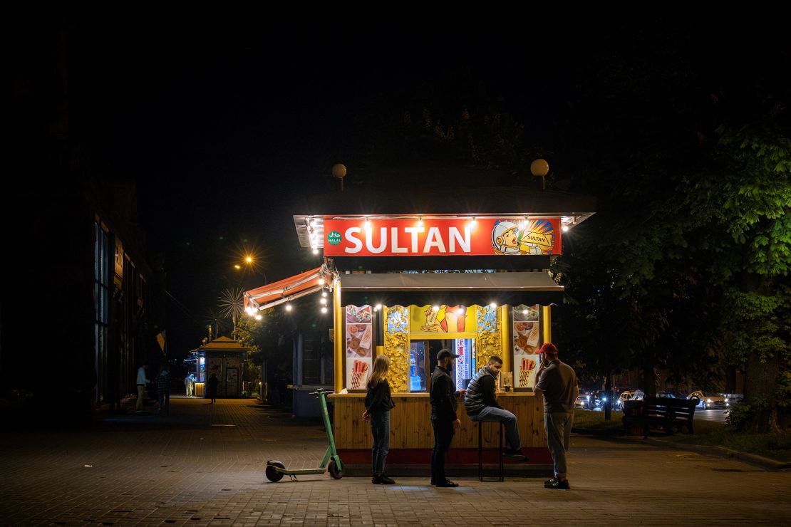 People stand at a fast-food stall in Kyiv during a partial blackout.