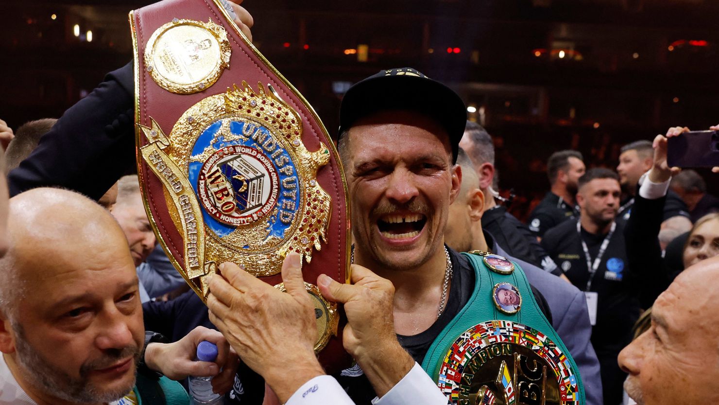 Oleksandr Usyk celebrates with the belts after becoming the undisputed heavyweight world champion.