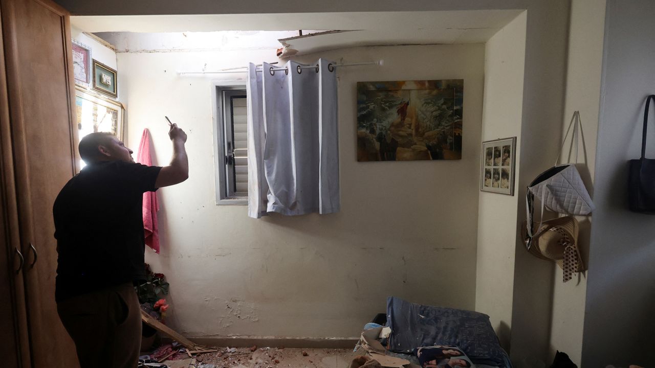 A person uses his phone to take pictures of the damage to a house after rockets were fired from the Gaza Strip towards Israel, amid the ongoing conflict in Gaza between Israel and Palestinian Islamist group Hamas, in Herzliya, Israel May 26 2024.