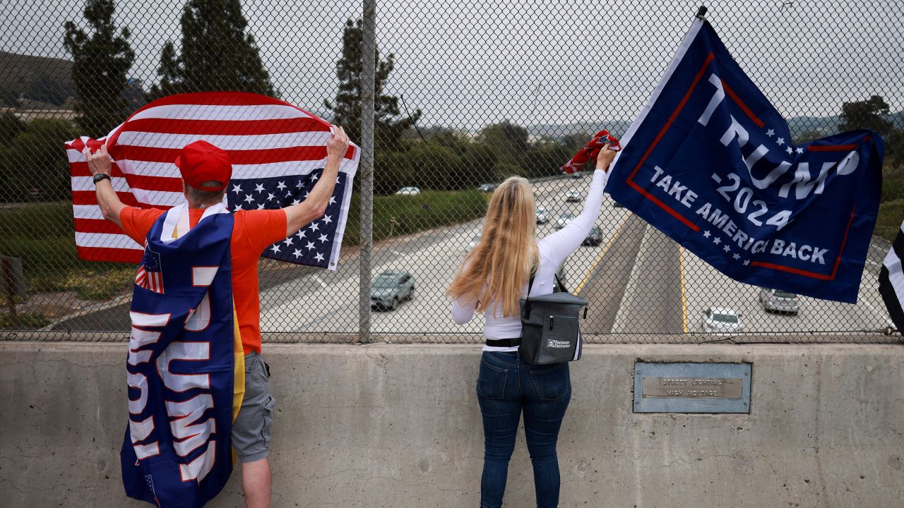 People stand with flags as "805 Patriots" take part in a rally in support of former U.S. President Donald Trump during what they call a "MAGA Cruise to stand up for Trump", in Thousand Oaks, California, U.S. June 1, 2024.