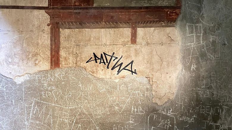 A sign made with a black marker by a tourist is pictured on the wall of a domus of the Herculaneum Archaeological Park, in Ercolano, Naples, Italy, in this handout picture obtained on June 3, 2024. Carabinieri/Handout via REUTERS    THIS IMAGE HAS BEEN SUPPLIED BY A THIRD PARTY