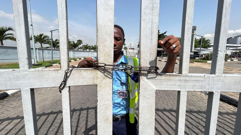 A worker stands by the gate of the domestic airport, which has been chained to prevent passengers from entering the premises, as Nigeria's main labour unions called for an indefinite strike from Monday after failing to agree to a new minimum wage with the government, in Lagos, Nigeria, on  June 3, 2024.