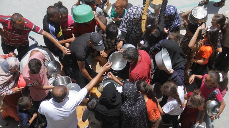 Palestinians gather to receive food cooked by a charity kitchen, as they struggle with food scarcity, basic necessities amid the conflict between Israel and Hamas continues, in Jabalia refugee camp, in the northern Gaza Strip, June 19, 2024. REUTERS/Mahmoud Issa