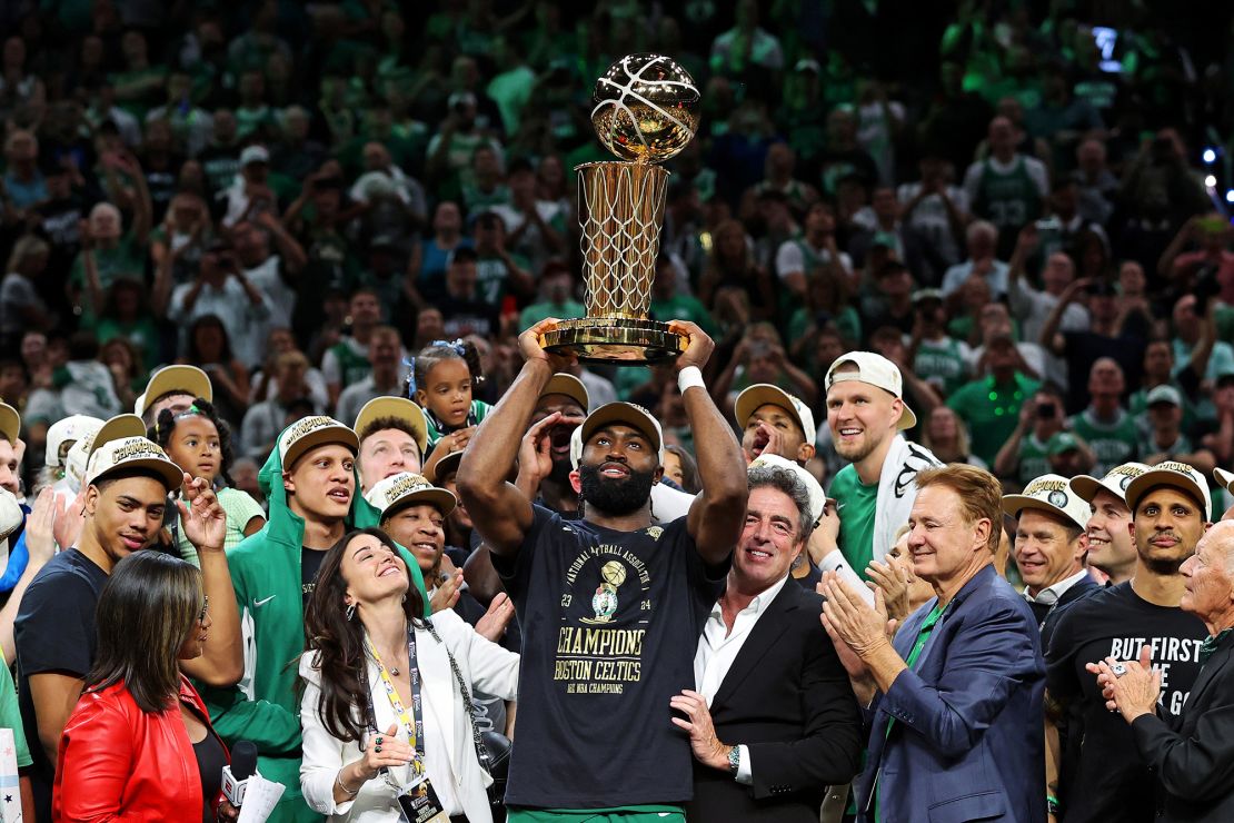 Jaylen Brown hoists the Larry O'Brien Trophy after defeating the Dallas Mavericks in the NBA Finals.