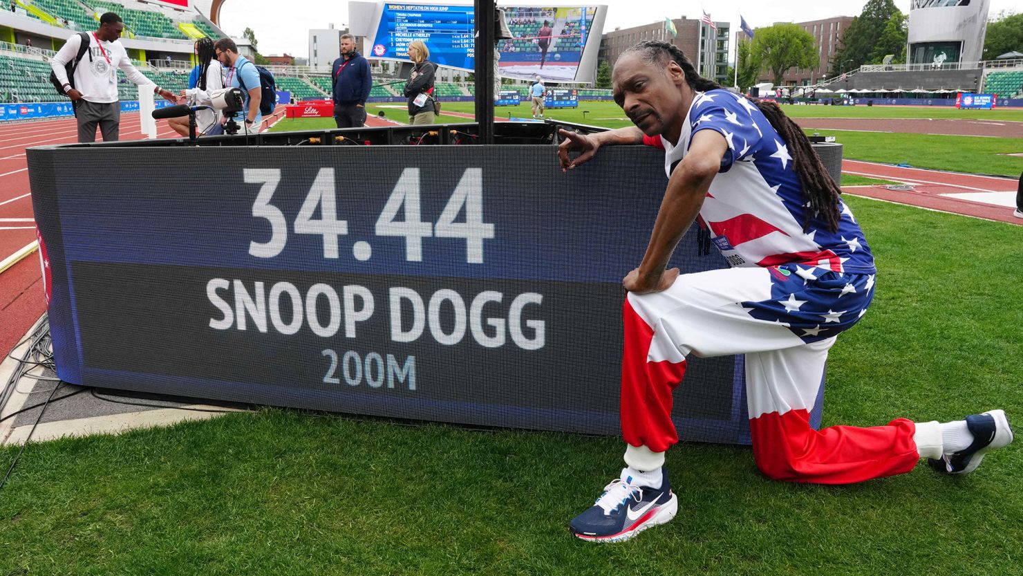 Snoop Dogg poses with his time after running the 200m in a guest appearance at the US Olympic trials.