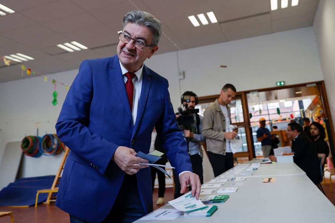 Jean-Luc Melenchon collects voting papers before casting his ballot at a polling station in Paris, June 30, 2024.