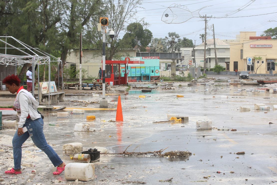 A woman walks through a street filled with debris in the Hastings neighborhood after Hurricane Beryl passed in Bridgetown, Barbados.