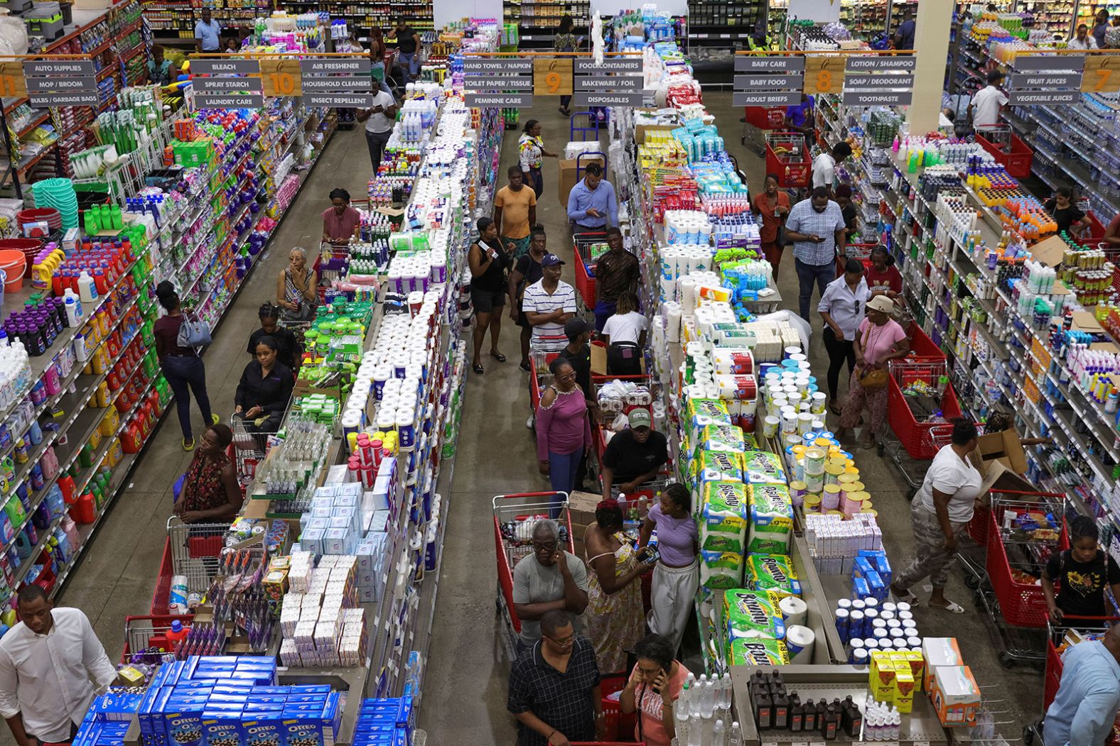 People in Kingston, Jamaica, wait in line with groceries as Beryl approaches.