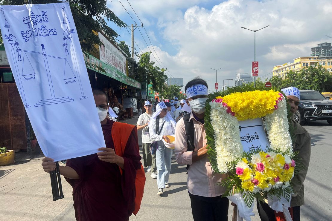 Environmental activists stage a mock funeral procession in the streets of Phnom Penh. An activist holds a placard that reads "Justice is dead."