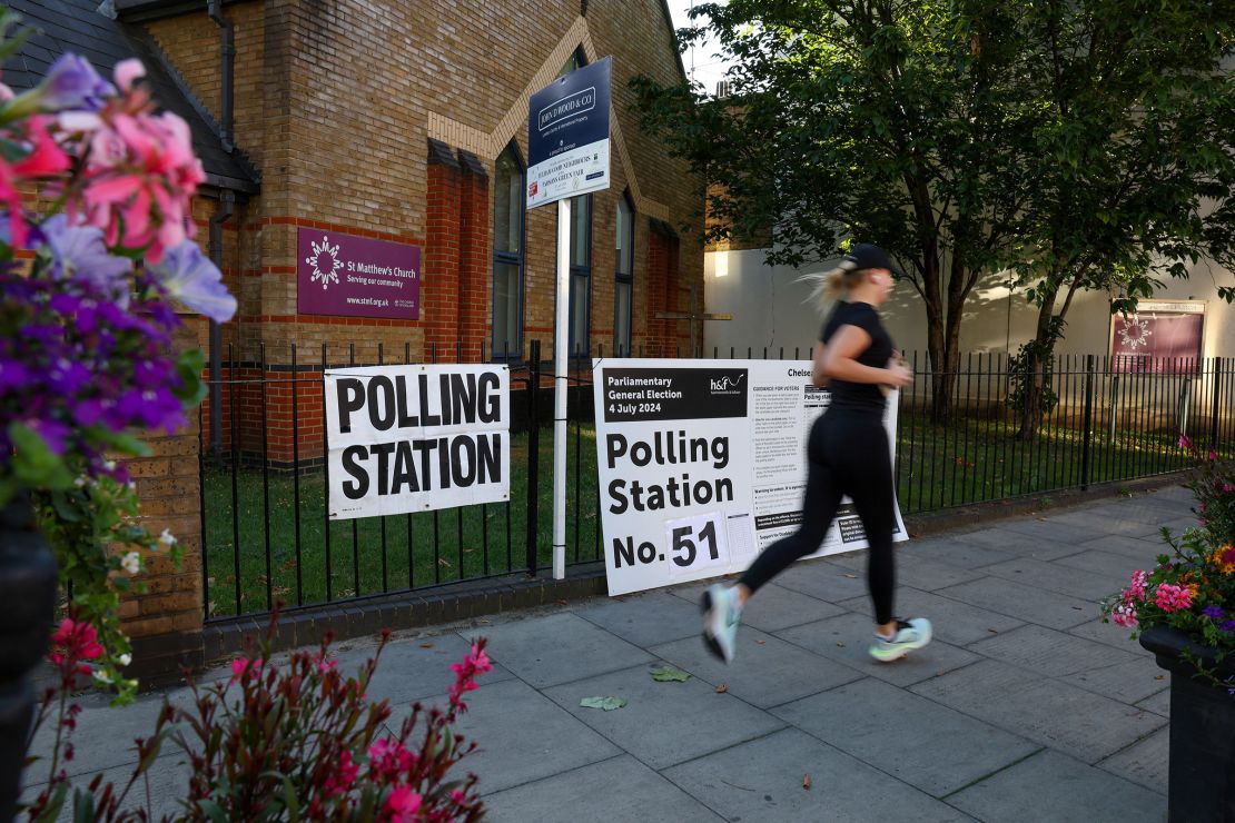 A person runs past a polling station shortly before the polls open and voting begins in the UK general election in London, Britain, on July 4, 2024.