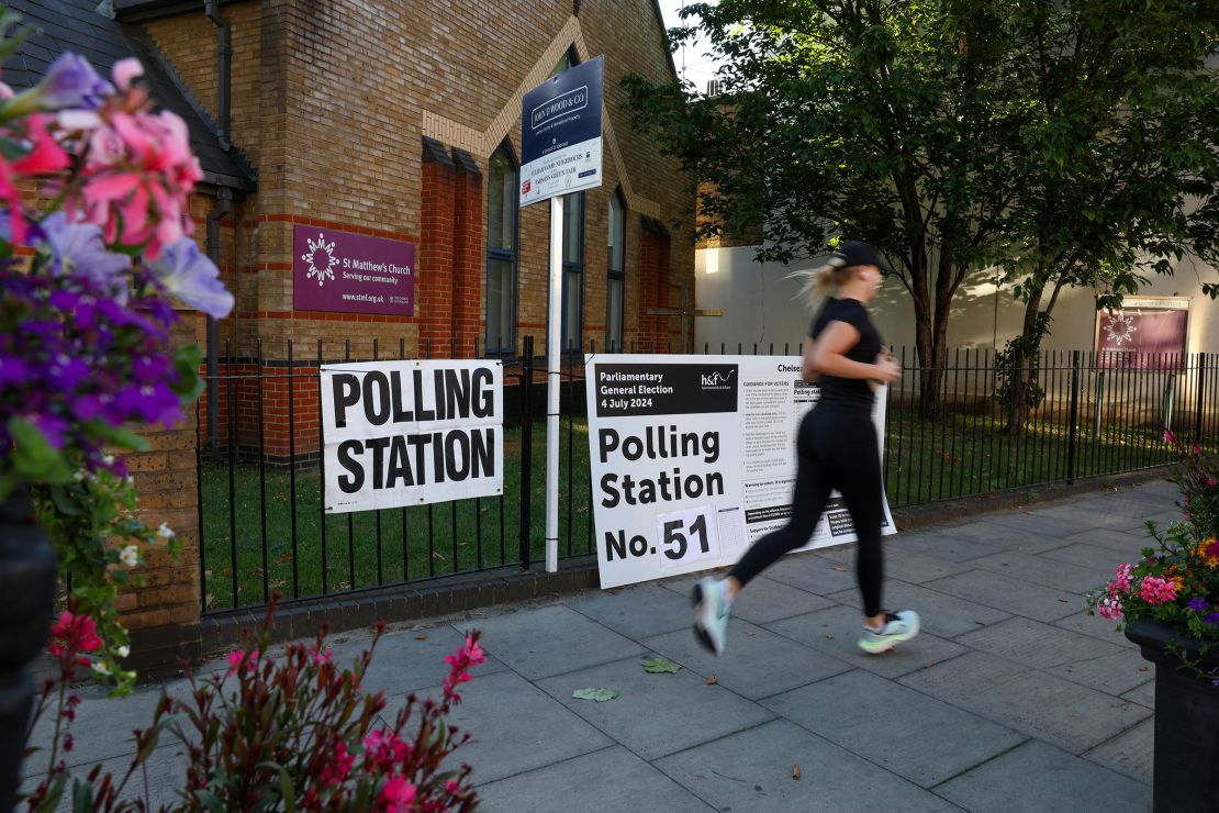 A person runs in front of a polling station just before the polls open and voting begins during the UK general election on July 4, 2024 in London, England.