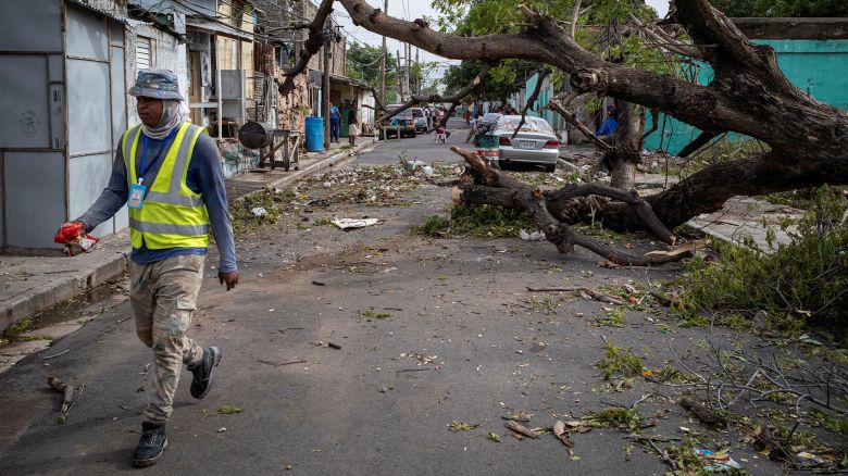 A man walks past a fallen tree after Hurricane Beryl hit the island, in Kingston, Jamaica, July 4, 2024. REUTERS/Marco Bello 