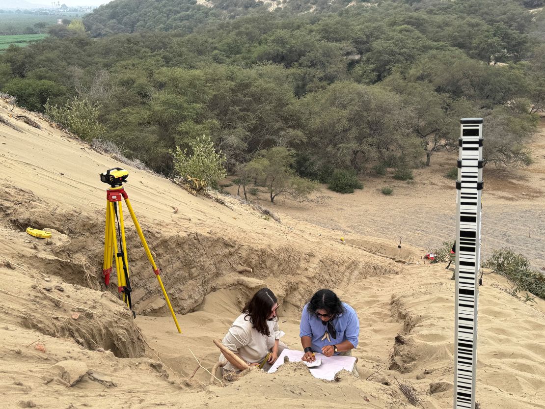 A team of archeologists work on what appear to be parts of a 4,000-year-old ceremonial temple buried in a sand dune in northern Peru.