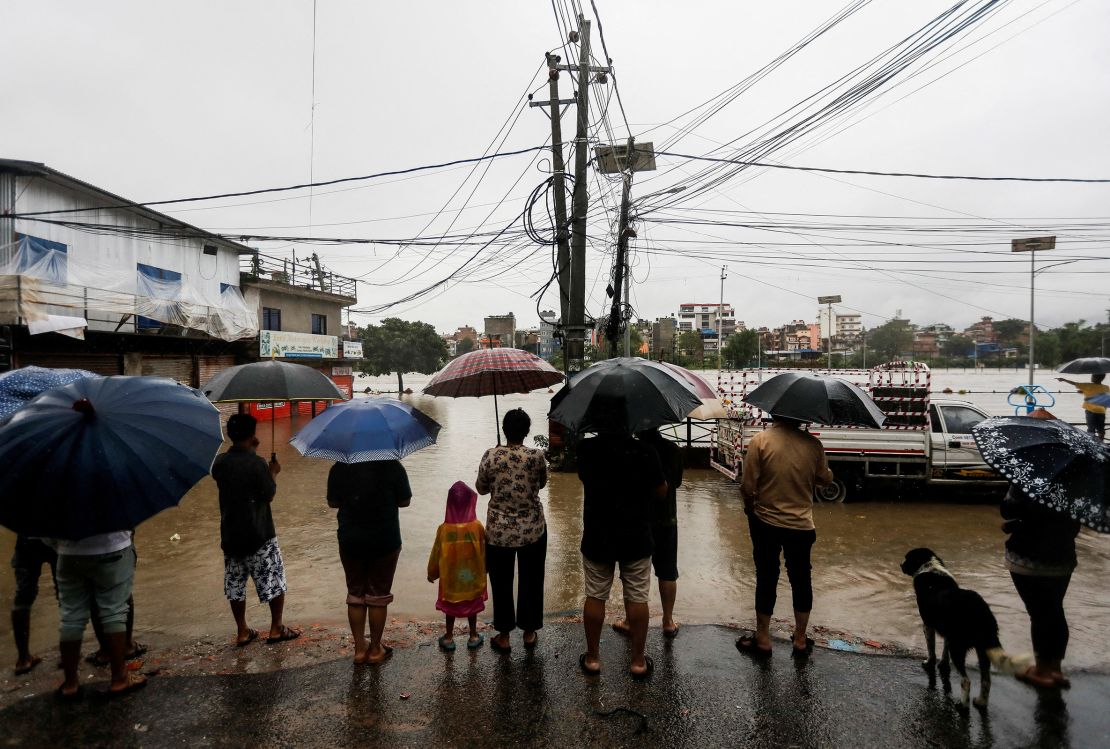 People look towards a flooded area along the bank of overflowing Bagmati River following heavy rains in Kathmandu, Nepal, July 6, 2024.