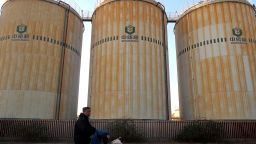 FILE PHOTO: A man cycles past storage facilities of China's state grain stockpiler Sinograin near Tianjin port, China December 12, 2019. REUTERS/Yilei Sun/File Photo