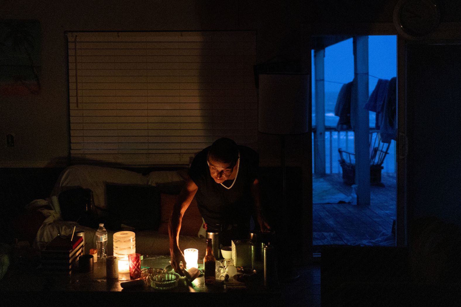 Marguerite Thomas lights candles at dusk in Surfside Beach, Texas, on Tuesday. The storm knocked out power to more than 2.5 million homes.