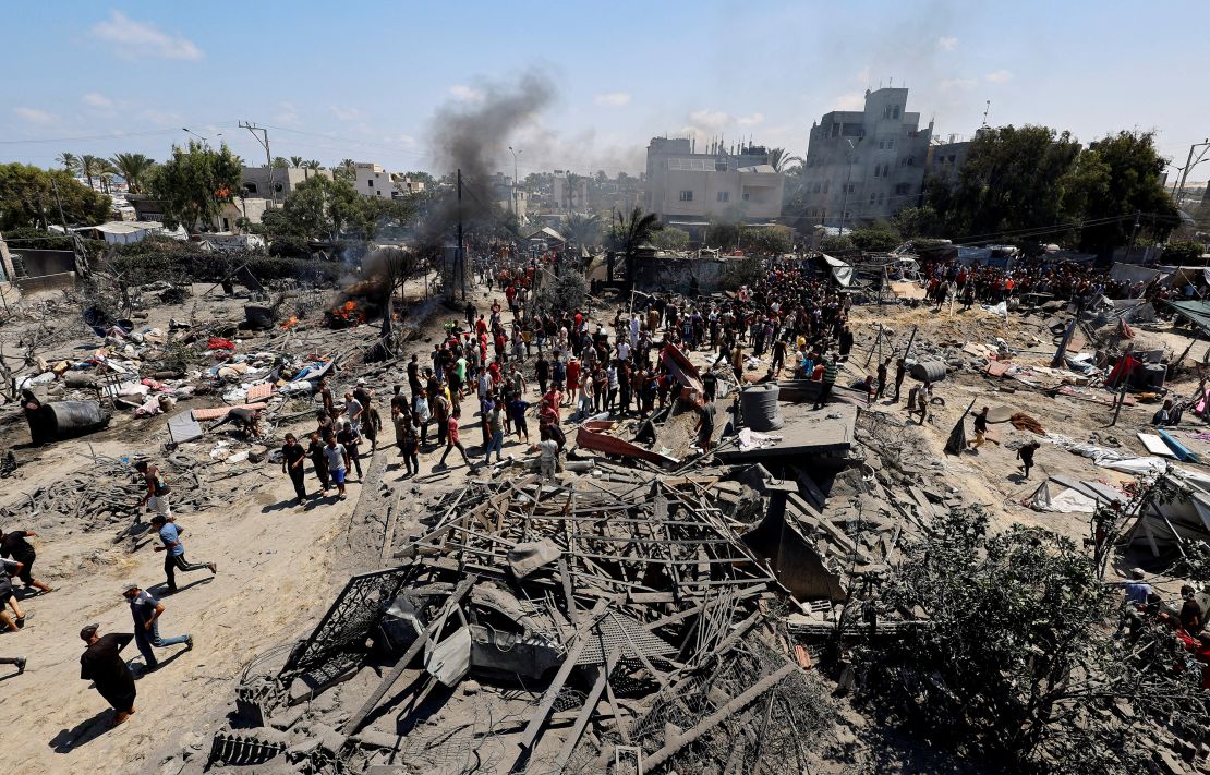 Palestinians gather near damaged buildings, following what Palestinians say was an Israeli strike at a tent camp in Al-Mawasi area in Khan Younis in the southern Gaza Strip July 13, 2024.