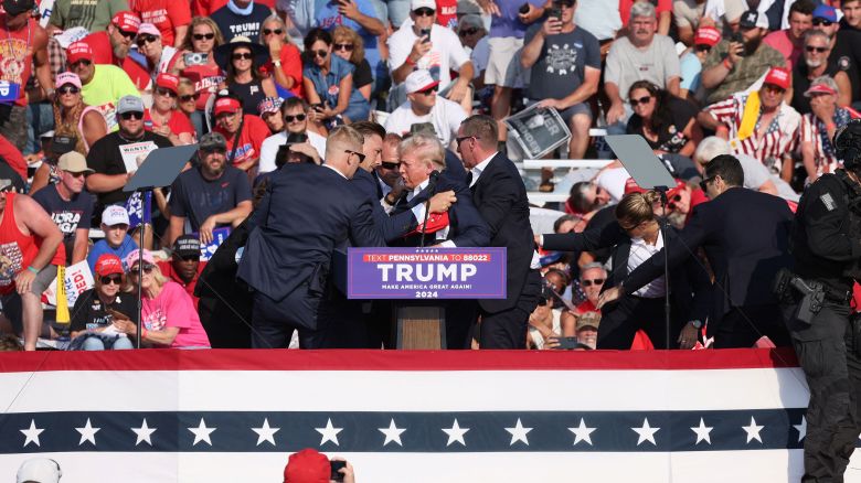 Republican presidential candidate and former U.S. President Donald Trump is assisted by guards during a campaign rally at the Butler Farm Show in Butler, Pennsylvania, U.S., July 13, 2024. REUTERS/Brendan McDermid
