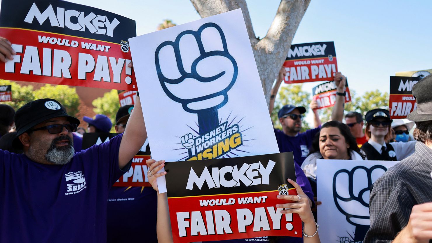 Workers gather with signs as the Teamsters union and Disney cast members demand fair wages at a rally outside Disneyland, in Anaheim, California, U.S., July 17, 2024.