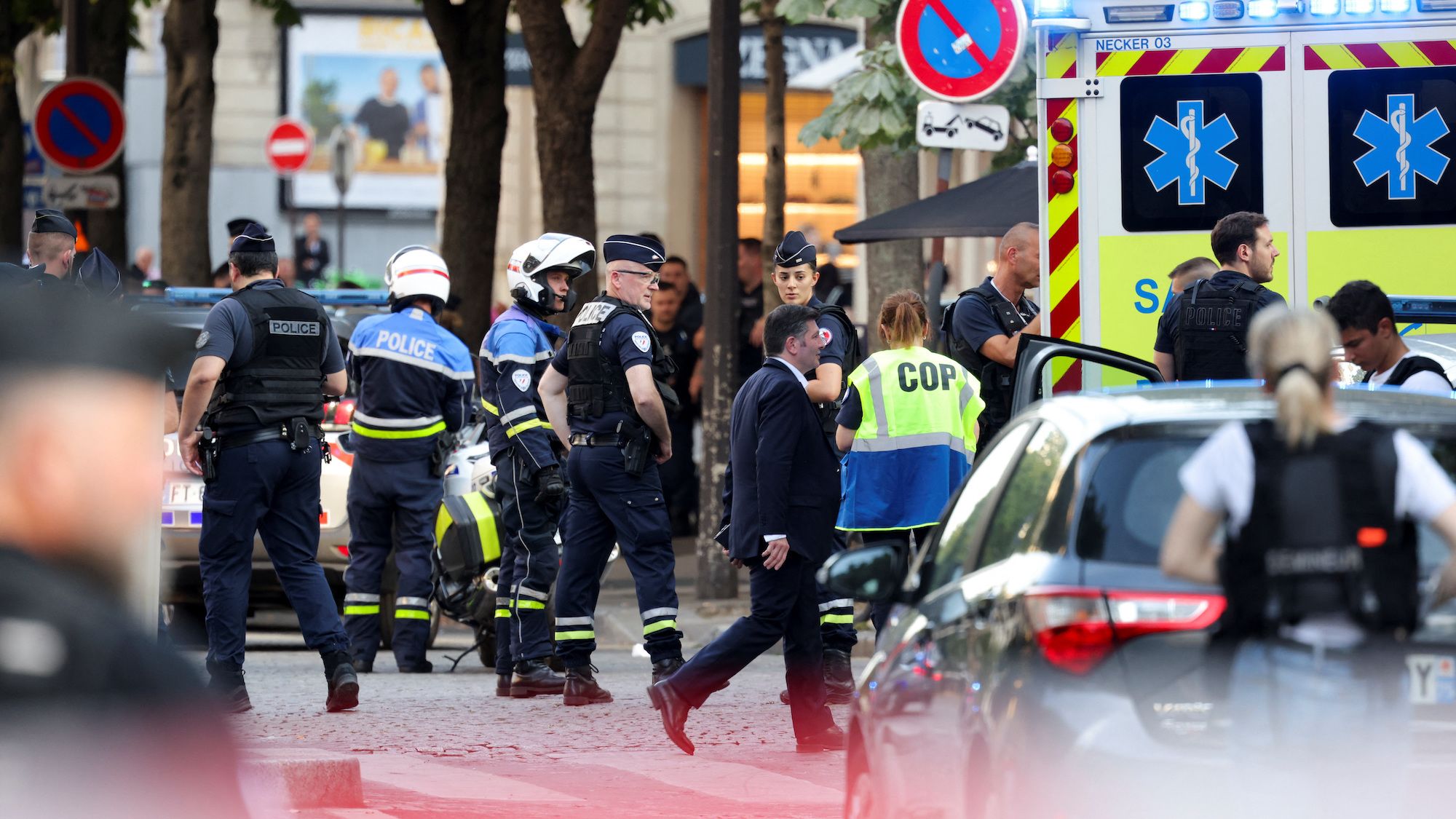 Police stand next to an ambulance after an officer was injured in an attack next to the Champs-Elysees avenue, in Paris, France July 18, 2024.