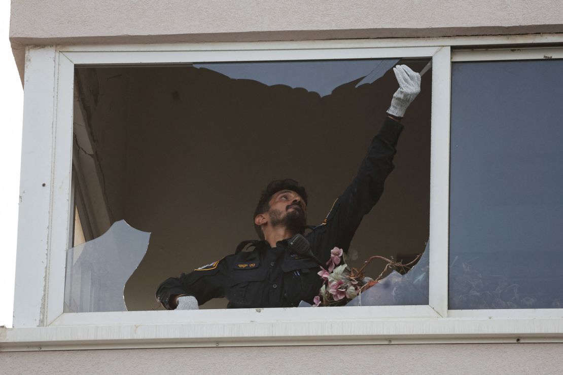 An investigator inspects a damaged window of a building at the site of an explosion in Tel Aviv on July 19, 2024.