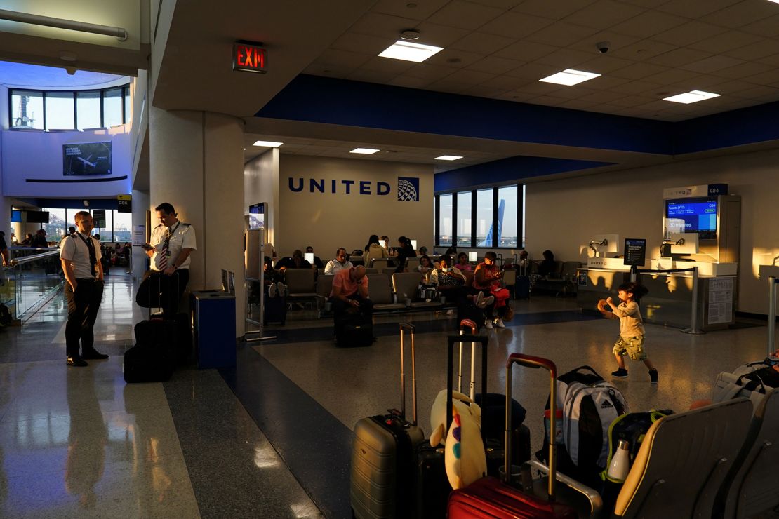 Passengers and airline pilots wait at Newark International Airport after United Airlines and other airlines grounded flights because of a worldwide tech outage.