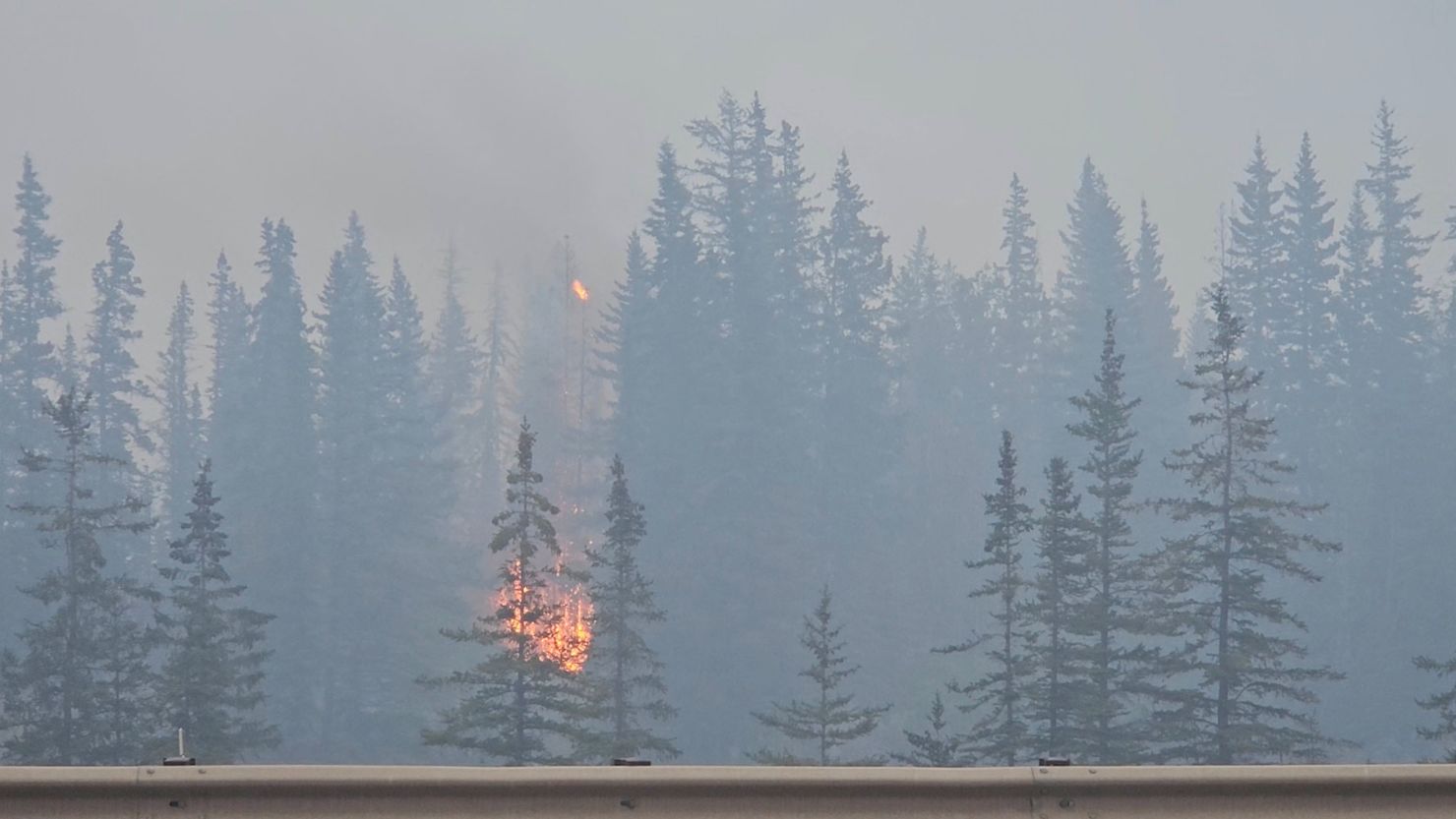 Flames and smoke rise from a burning wildfire, as seen from a highway, in Jasper, Alberta, Canada, on Tuesday in this screen grab obtained from a social media video.