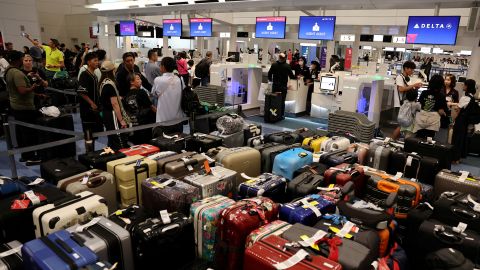 Passengers stands in a line at Delta Airlines’ counter following a global IT outage, at Haneda International Airport in Tokyo, Japan July 19, 2024.