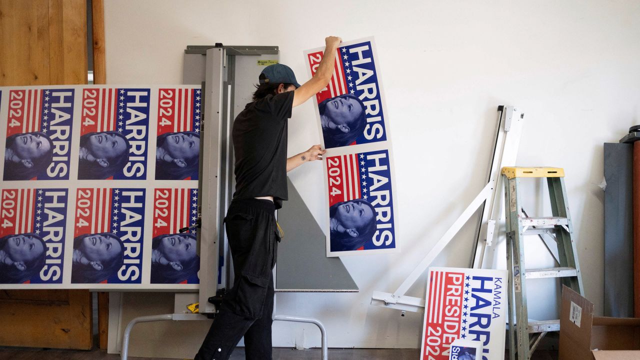 A print production specialist at a print shop in Tucson, Arizona cuts a run of 100 yard signs in support of Vice President Kamala Harris' presidential campaign on July 25, 2024.